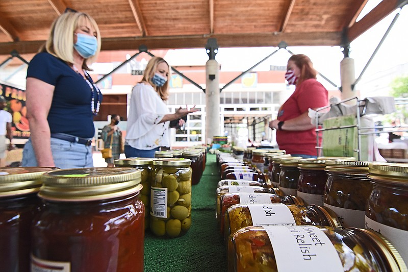 Sally Smith (left) of Cleveland, Miss. and her daughter Maria Gray (center) of Maumelle talk with Brandye Brater, an employee of Rick’s Farm Stand, while checking out the variety of jams and relishes for sale Saturday at the opening day of the Little Rock Farmers’ Market. The farmers’ market also celebrated 501 Day and the re-opening of Ottenheimer Market Hall. See more photos at arkansasonline.com/502market/.
(Arkansas Democrat-Gazette/Staci Vandagriff)