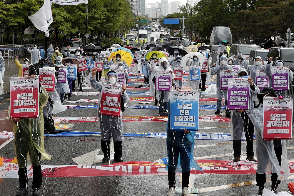Members of the Korean Confederation of Trade Unions stage a May Day rally demanding better working conditions and expanding labor rights in Seoul, South Korea, Saturday, May 1, 2021. The signs read: "Let's solve inequality." (AP Photo/Ahn Young-joon)