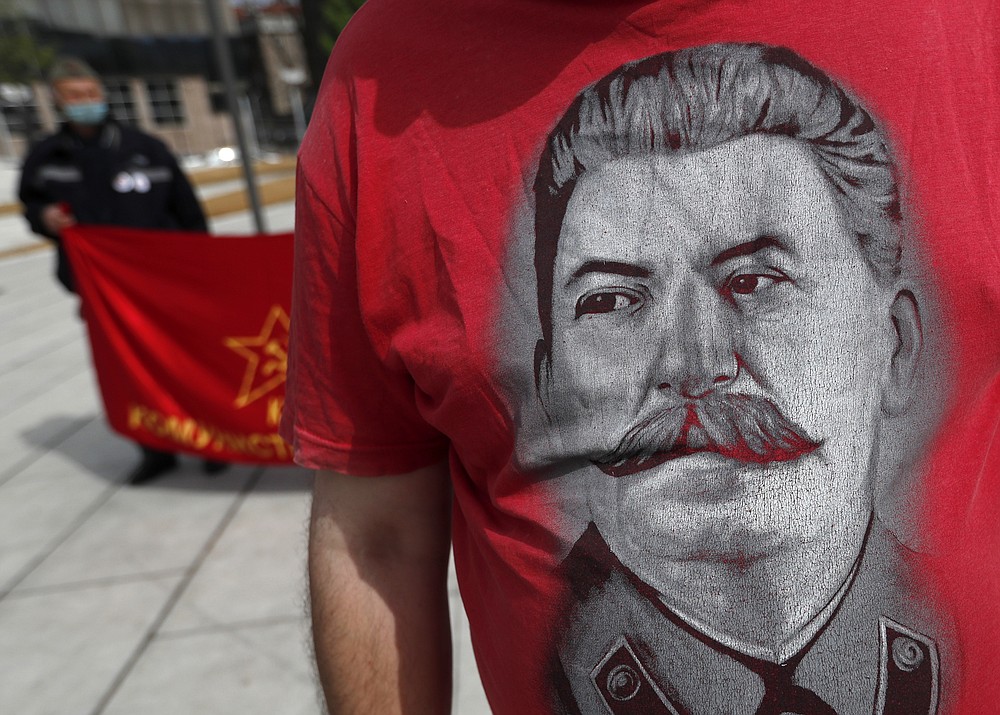A man wearing a shirt with the image of former Soviet dictator Joseph Stalin attends a May Day rally on International Workers Day in Belgrade, Serbia, Saturday, May 1, 2021. Activists marked May Day with defiant rally. (AP Photo/Darko Vojinovic)