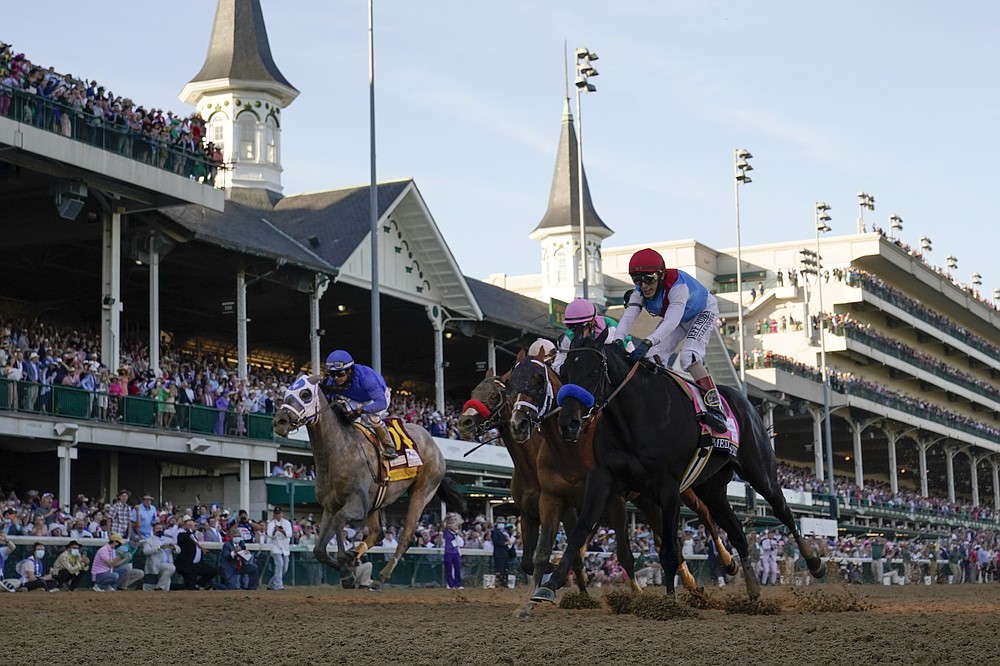 John Velazquez riding Medina Spirit, right, leads Florent Geroux on Mandaloun, Flavien Prat riding Hot Rod Charlie and Luis Saez on Essential Quality to win the 147th running of the Kentucky Derby at Churchill Downs, Saturday, May 1, 2021, in Louisville, Ky. (AP Photo/Jeff Roberson)