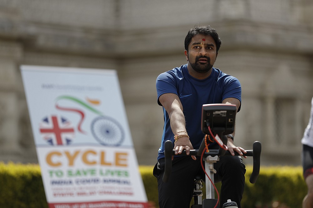 A man takes part in "Cycle to Save Lives" a 48 hour, non-stop static relay cycle challenge at the BAPS Shri Swaminarayan Mandir, also know as the Neasden Temple, the largest Hindu temple in the UK, in north London, to raise money to help coronavirus relief efforts in India, Saturday, May 1, 2021. The challenge sees people combining at three different venues in the UK, cycling in a static relay the equivalent distance of 7,600 Km, which is the distance from London to Delhi. (AP Photo/Matt Dunham)