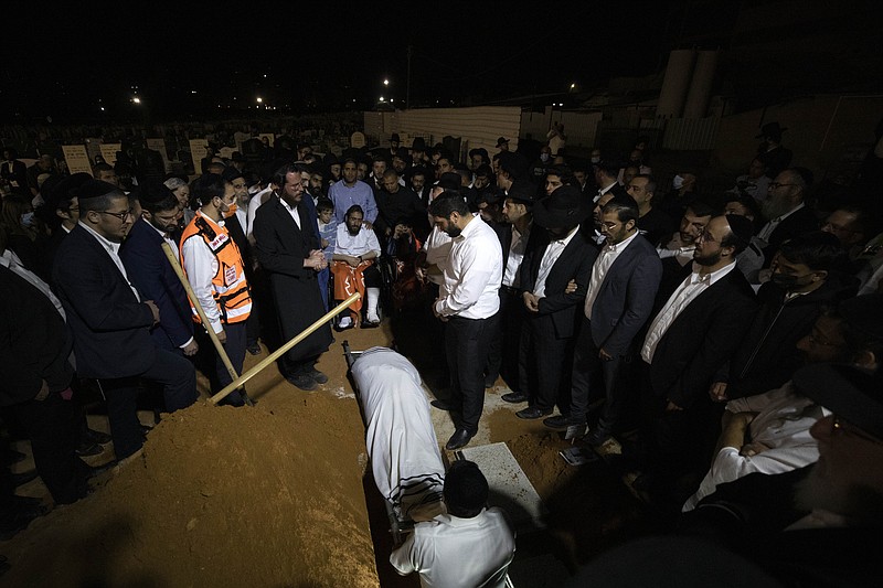 Mourners gather around the grave during the funeral of Yedidyia Chiyuis at a cemetery in Petah Tikva, Sunday, May 2, 2021. A stampede at a religious festival attended by tens of thousands of ultra-Orthodox Jews in northern Israel killed dozens of people and injured about 150 early Friday, medical officials said. It was one of the country's deadliest civilian disasters. (AP Photo/Sebastian Scheiner)