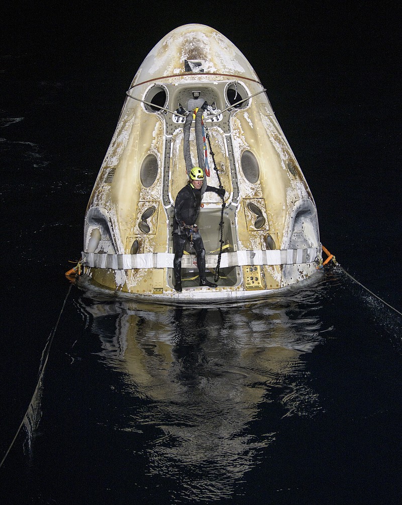 Support teams work around the SpaceX Crew Dragon Resilience spacecraft shortly after it landed with NASA astronauts Mike Hopkins, Shannon Walker, and Victor Glover, and Japan Aerospace Exploration Agency (JAXA) astronaut Soichi Noguchi aboard in the Gulf of Mexico off the coast of Panama City, Florida, Sunday, May 2, 2021. NASA's SpaceX Crew-1 mission was the first crew rotation flight of the SpaceX Crew Dragon spacecraft and Falcon 9 rocket with astronauts to the International Space Station as part of the agency's Commercial Crew Program. (Bill Ingalls/NASA via AP)