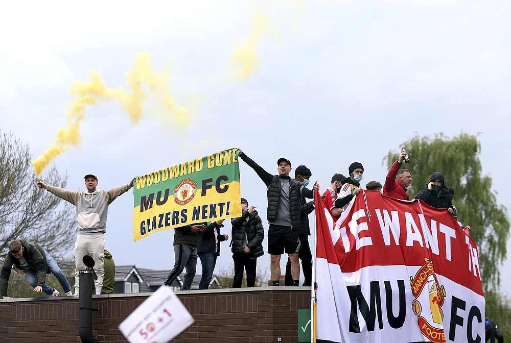 Fans holds up banners as they protest against the Glazer family, owners of Manchester United, before their Premier League match against Liverpool at Old Trafford, Manchester, England, Sunday, May 2, 2021. (Barrington Coombs/PA via AP)