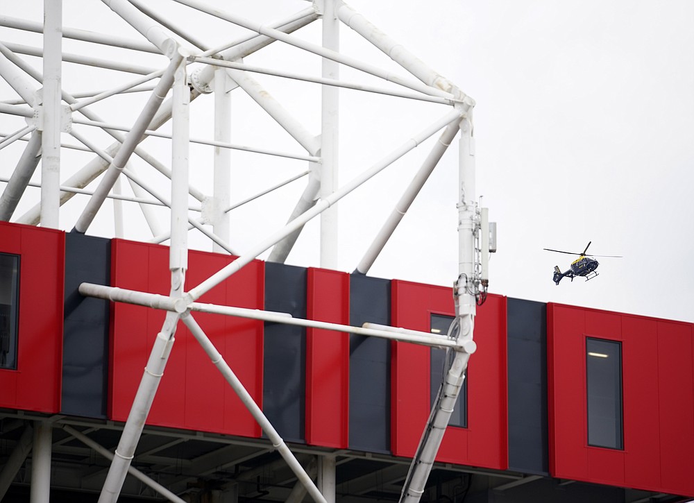 A police helicopter flies over the Old Trafford stadium before the English Premier League soccer match between Manchester United and Liverpool, in Manchester, England, Sunday, May 2, 2021. Manchester United supporters have stormed into the stadium and onto the pitch ahead of Sunday's game against Liverpool as fans gathered outside Old Trafford to protest against the ownership. (AP Photo/Dave Thompson, Pool)