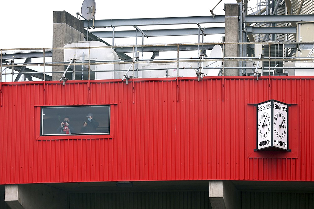 Fans inside the stadium look out from a window as they protest against the Glazer family, owners of Manchester United, before their Premier League match against Liverpool at Old Trafford, Manchester, England, Sunday, May 2, 2021. Manchester United supporters have stormed into the stadium and onto the pitch ahead of Sunday’s game against Liverpool as fans gathered outside Old Trafford to protest against the ownership. (Barrington Coombs/PA via AP)