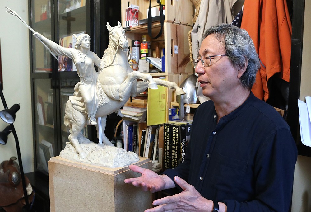 Artist Longhua Xu discusses his latest sculpture in his Hot Springs studio Wednesday. - Photo by Richard Rasmussen of The Sentinel-Record