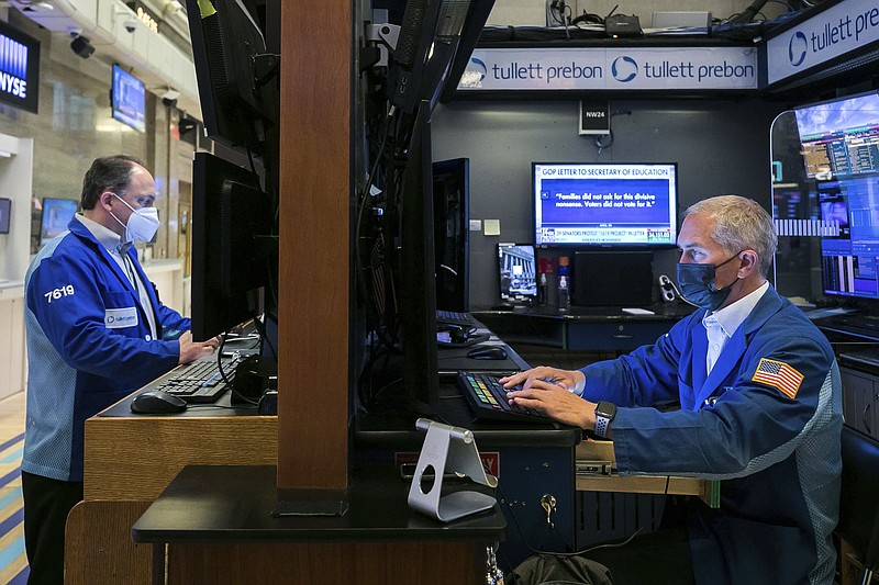 In this photo provided by the New York Stock Exchange, trader Timothy Nick, right, works in his booth on the floor, Monday May 3, 2021. Stocks were solidly higher Monday, and investors cheered a strong dose of positive earnings reports as well as economic data that showed the U.S. economy is growing. (Courtney Crow/New York Stock Exchange via AP)