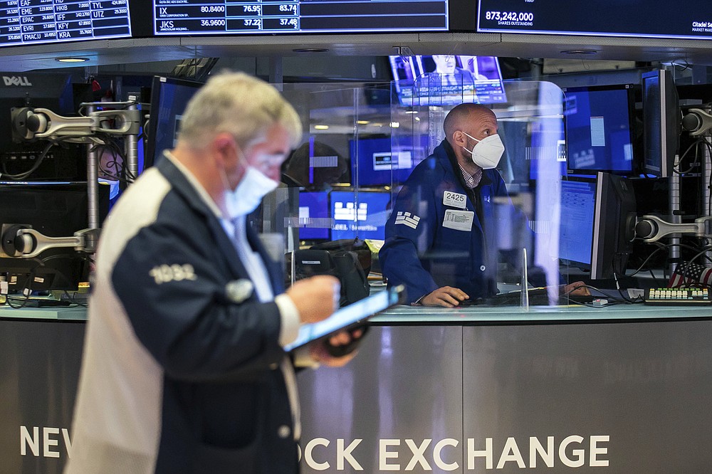 In this photo provided by the New York Stock Exchange, specialist Meric Greenbaum, right, works at his post on the floor, Monday May 3, 2021. Stocks were solidly higher Monday, and investors cheered a strong dose of positive earnings reports as well as economic data that showed the U.S. economy is growing. (Courtney Crow/New York Stock Exchange via AP)