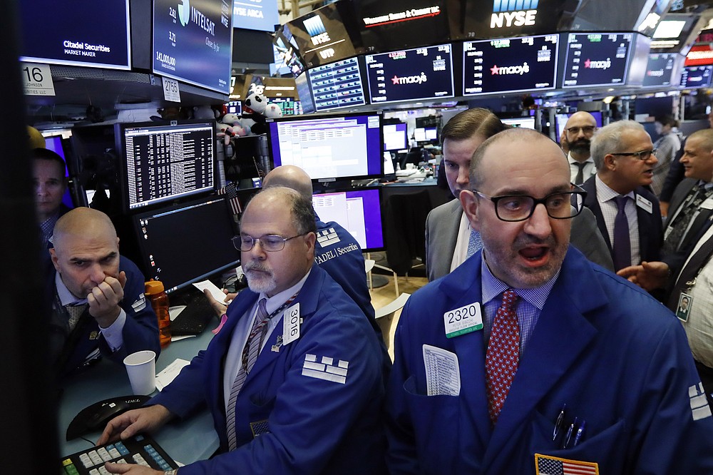 Specialist Peter Giacchi, right, calls out prices on the floor of the New York Stock Exchange, in this Wednesday, Feb. 5, 2020, file photo. Stocks were solidly higher Monday, May 3, 2021, and investors cheered a strong dose of positive earnings reports as well as economic data that showed the U.S. economy is growing. (AP Photo/Richard Drew, File)
