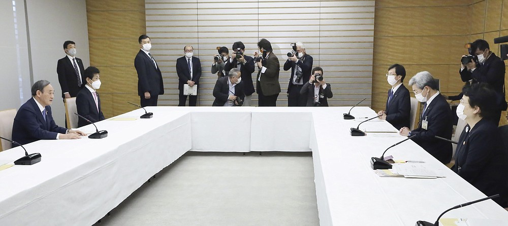 Japanese Prime Minister Yoshihide Suga, left, holds a meeting with Toshiko Fukui, right, president of the Japanese Nursing Association, and Toshio Nakagawa, second from right, president of the Japan Medical Association, at his office in Tokyo on April 30, 2021. Some nurses in Japan are incensed at a request from Tokyo Olympic organizers to have 500 of them dispatched to help out with the games. They say they’re already near the breaking point dealing with the coronavirus pandemic. (Toshiyuki Matsumoto/Kyodo News via AP)