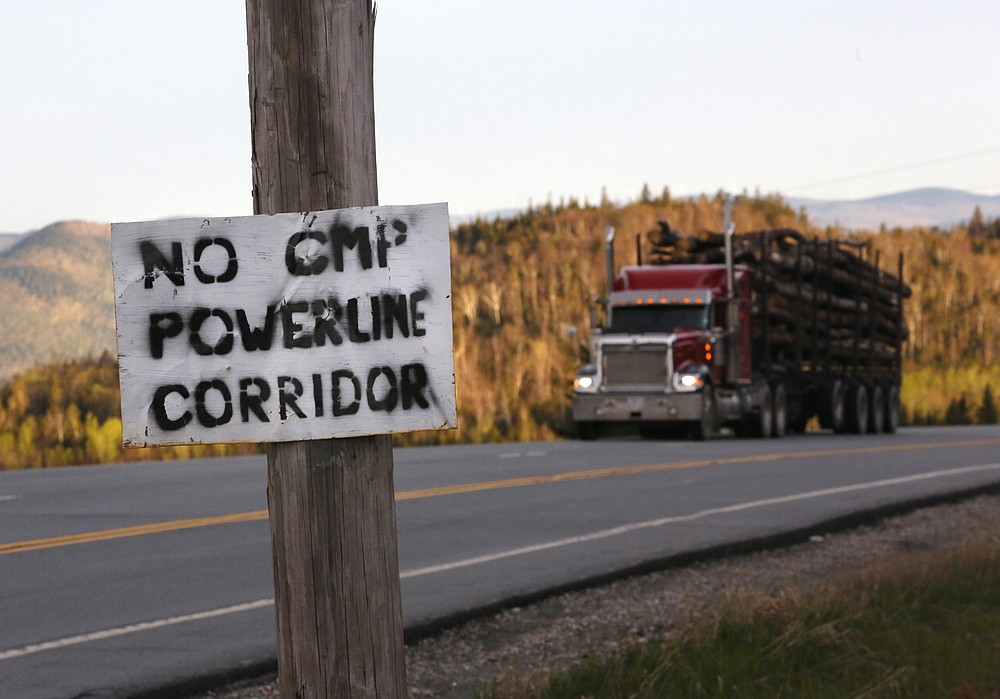 FILE - In this Tuesday, May 28, 2019, file photo, a homemade sign is posted on a telephone pole in protest of Central Maine Power's controversial hydropower transmission corridor in Jackman, Maine. A $1 billion hydropower electricity transmission corridor called the New England Clean Energy Connect would cut through sparsely populated woodlands. Environmental groups disagree about whether the 145-mile corridor comes at too high a cost in loss of trees and wildlife habitat. (AP Photo/Robert F. Bukaty, File)