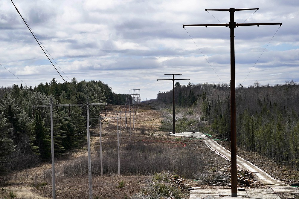 New metal towers stand on land recently cleared on an existing Central Maine Power power line corridor, Monday, April 26, 2021, near Bingham, Maine. As President Joe Biden's administration plans to fight climate change by weaning the nation off fossil fuels, these large-scale renewable energy projects are the source of conflict within a seemingly unlikely group: environmentalists. (AP Photo/Robert F. Bukaty)