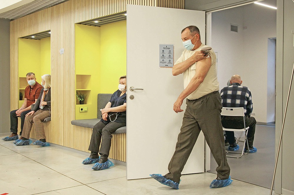 A man wearing a face mask to protect against coronavirus leaves a room after vaccinating with Russia's Sputnik V coronavirus vaccine at a shopping center in Nizhny Novgorod, Russia, Friday, April 2, 2021. Russia has boasted about being the first country in the world to authorize a coronavirus vaccine and rushed to roll it out earlier than other countries, even as large-scale testing necessary to ensure its safety and effectiveness was still ongoing. (AP Photo/Roman Yarovitcyn)