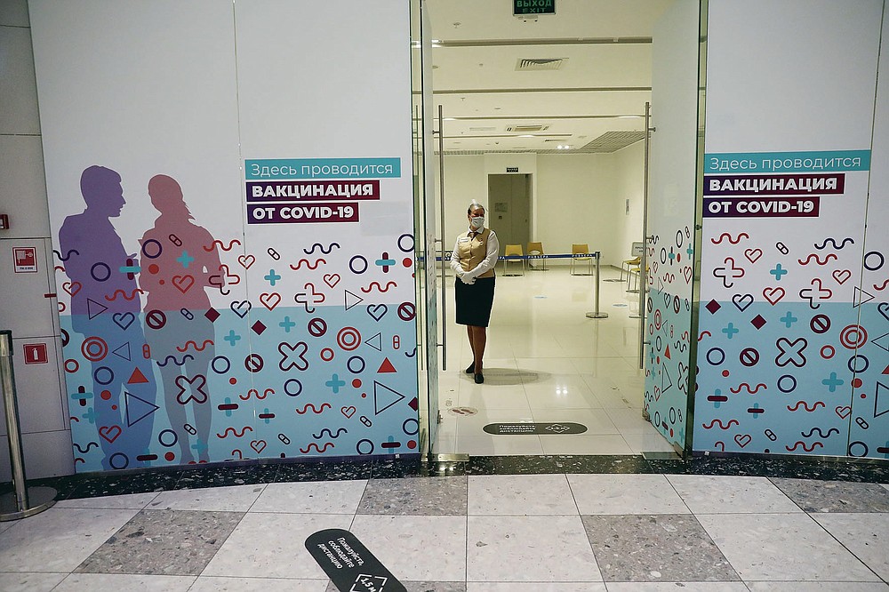 An employee stand waiting for customers at a vaccination point in Moscow, Russia, Wednesday, April 7, 2021. The low vaccine uptake hinges on several factors. Russian drug makers have been slow to ramp up mass production of the vaccine, leading to shortages in many regions last month. As more shots became available, people's unwillingness to get them emerged as another apparent problem. So far only 27.9 million two-dose sets have been produced, and only 15 million have been released into circulation after undergoing quality control. (AP Photo/Pavel Golovkin)