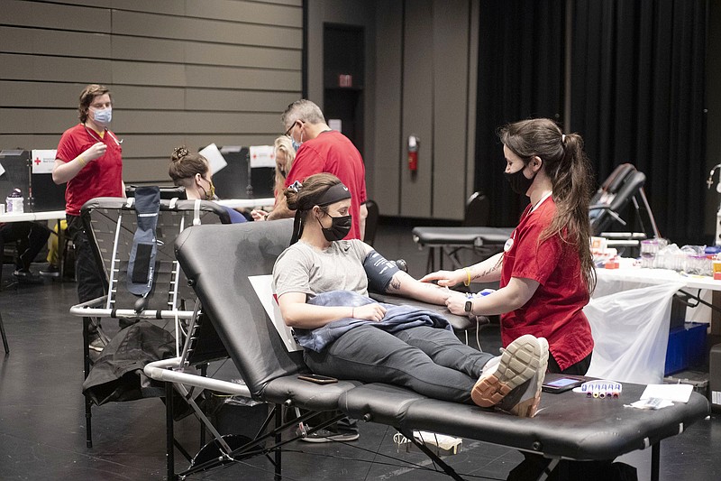 Collection technician Payton Reed of Rogersville MO (right) draws blood Tuesday from Kortney Carlton ((CQ)) of Fayetteville during a University of Arkansas American Red Cross Student Organization blood drive at the Walton Arts Center in Fayetteville. The blood drive continues Wednesday in the Starr Theater with live entertainment. For more information or to donate see www.redcrossblood.org Visit nwaonline.com/210505Daily/ and nwadg.com/photo. (NWA Democrat-Gazette/J.T. Wampler)