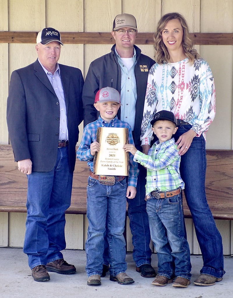 Westside Eagle Observer/RANDY MOLL
Jim Singleton (left), chairman of the Benton County Farm Family of the Year selection committee, presented the 2021 Benton Farm Family of the Year plaque to Kaleb and Chrisie Smith of Gentry, along with their two boys, Paden, 7, and Paxton, 5, at their farm near Gentry on Wednesday, May 5, 2021.