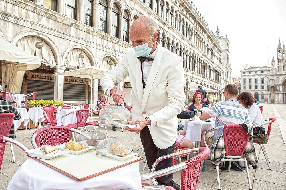 A waiter works in St. Mark's Square  in Venice, northern Italy, Saturday, might 1, 2021. Italy is slowly reopening after six months of turning virus closures permitting outdoor dining. (Filippo Ciappi/LaPresse via AP)