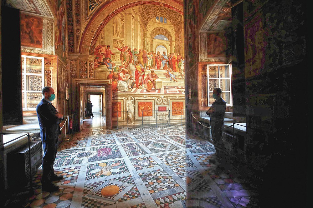 a worker putting on a mask to avoid the scatter of COVID-19 stands inside a Raphael area of Vatican Museums on their reopening, in Rome, Monday, May 3, 2021. The Vatican Museums reopened Monday to visitors after a shutdown following COVID-19 containment actions. (AP Photo/Alessandra Tarantino)