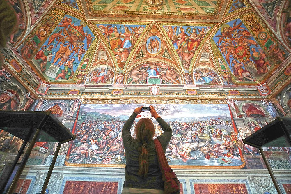 a visitor admires a Raphael Room inside the Vatican Museums on the reopening, in Rome, Monday, might 3, 2021. The Vatican Museums reopened Monday to visitors after a shutdown after COVID-19 containment actions. (AP Photo/Alessandra Tarantino)