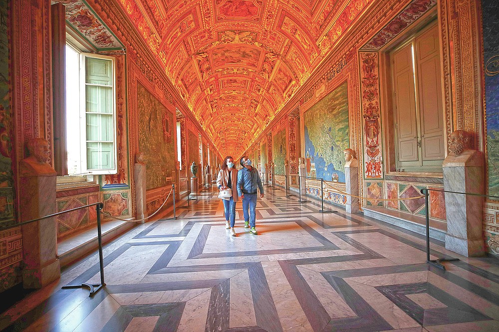 Visitors using masks to stop the spread of coronavirus walks in the Vatican Museum after it reopened, in Rome, Monday, May 3, 2021. The Vatican Museums reopened Monday to site visitors after a shutdown after COVID-19 containment steps. (AP Photo/Alessandra Tarantino)