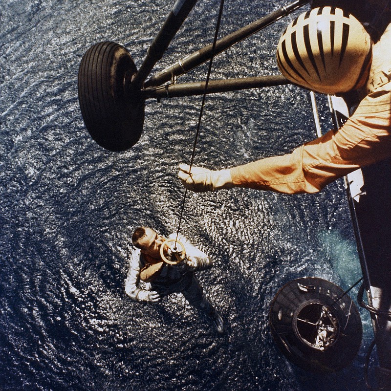 In this May 5, 1961 photo made available by NASA, astronaut Alan Shepard is retrieved by a U.S. Marine helicopter after splashdown in the Atlantic Ocean at the end of his sub-orbital flight down range from the Florida eastern coast. (NASA via AP)