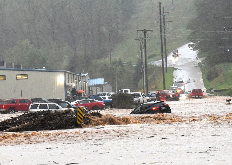 Flood water surges Wednesday April 28 2021 across Dream Valley Road on the east edge of Rogers, about 100 yards south of Arkansas 12. (NWA Democrat-Gazette/Flip Putthoff)