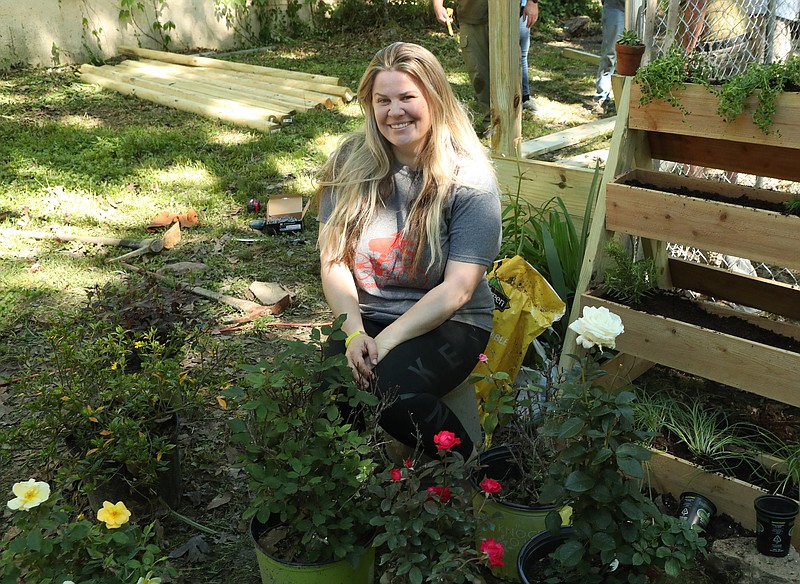 U.S. Air Force veteran Amy Rose, of Hot Springs, sits among some of the roses about to be planted in her yard Wednesday, courtesy of a nonprofit veterans’ group, Frontline Gardens, of Tennessee. - Photo by Richard Rasmussen of The Sentinel-Record