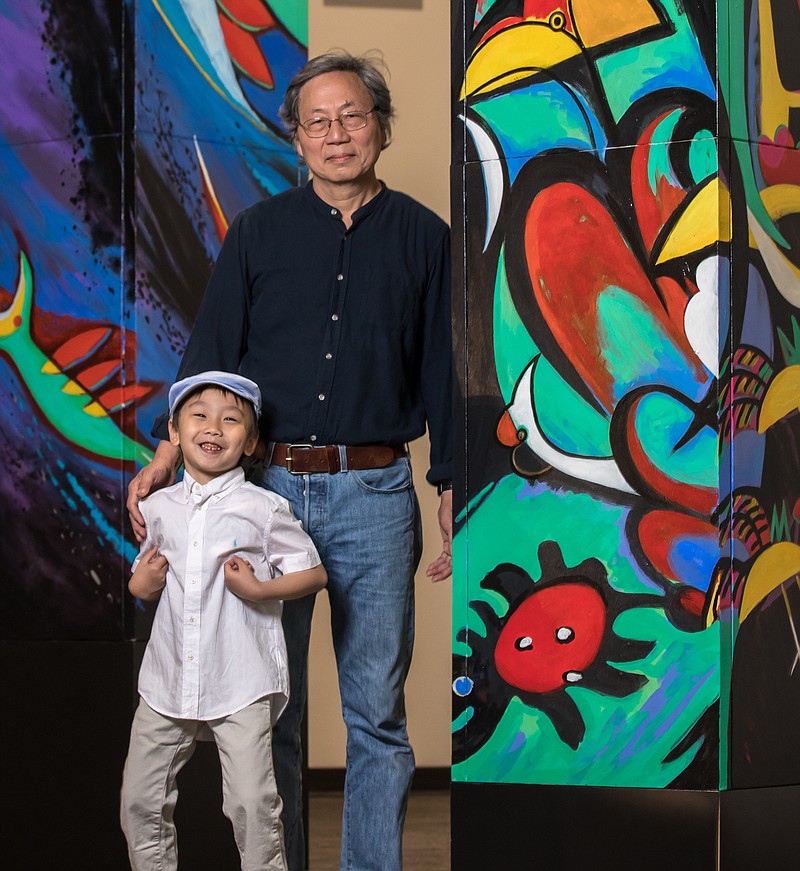 Longhua Xu, right, and his grandson Han Xu, stand with artwork the two collaborated on for an exhibit at the Mid-America Science Museum. - Submitted photo