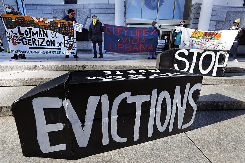 FILE - In this Jan. 13, 2021, file photo, demonstrators hold signs in front of the Edward W. Brooke Courthouse in Boston. A federal judge has ruled, Wednesday, May 5, 2021, that the Centers for Disease Control exceeded its authority when it imposed a federal eviction moratorium to provide protection for renters out of concern that having families lose their homes and move into shelters or share crowded conditions with relatives or friends during the pandemic would further spread the highly contagious virus. (AP Photo/Michael Dwyer, File)