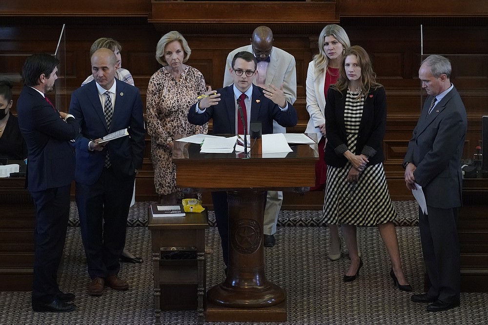 Rep. Briscoe Cain, R-Houston, center, stands with co-sponsors as he answers questions and speaks in favor of HB 6, an election bill, in the House Chamber at the Texas Capitol in Austin, Texas, Thursday, May 6, 2021. (AP Photo/Eric Gay)