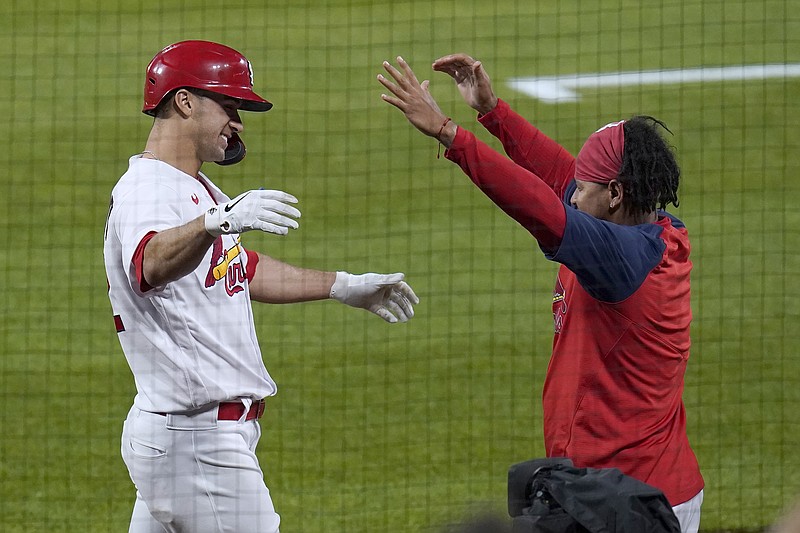 St. Louis Cardinals' Jack Flaherty, left, gets a hug from teammate Carlos Martinez after hitting a solo home run during the third inning of a baseball game against the Colorado Rockies Friday, May 7, 2021, in St. Louis. (AP Photo/Jeff Roberson)