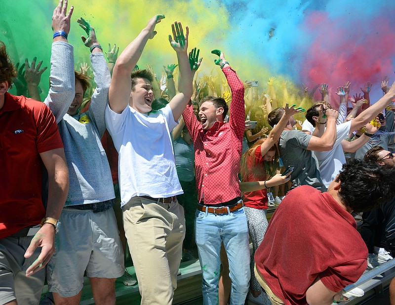 Anthony Wilson (left) and Declan Baldwin, both seniors at Bentonville High School, join other members of the graduating class in sending colored powder skyward in celebration Wednesday, May 5, 2021, during the school√ïs Senior Sendoff at Tiger Stadium in Bentonville. The current pandemic will again affect graduations at schools in Northwest Arkansas. Visit nwaonline.com/210510Daily/ for today's photo gallery. 
(NWA Democrat-Gazette/Andy Shupe)