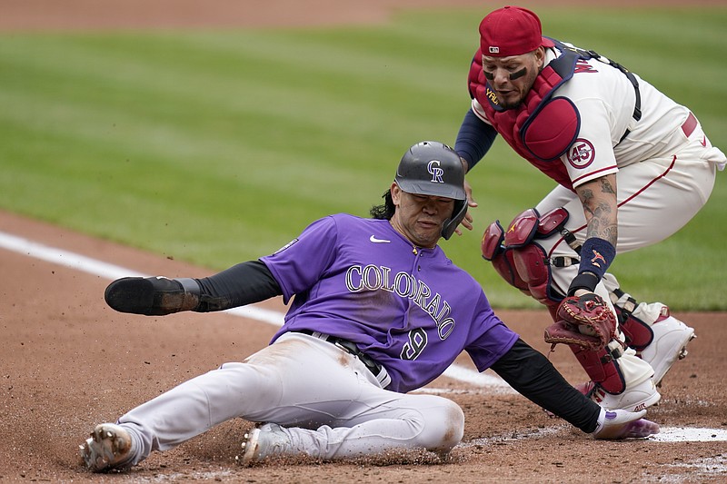 Colorado Rockies' Connor Joe (9) slides after being tagged out at home by St. Louis Cardinals catcher Yadier Molina during the second inning of a baseball game Saturday, May 8, 2021, in St. Louis. (AP Photo/Jeff Roberson)