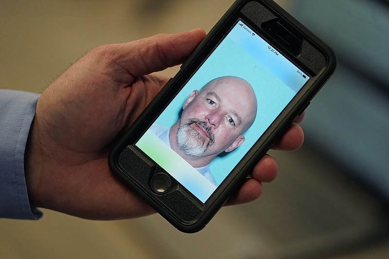 Ryan Williams, with the Utah Drivers License Division, holds his cell phone with the pilot version of the state's mobile ID on Wednesday, May 5, 2021, in West Valley City, Utah. The card that millions of people use to prove their identity to everyone from police officers to liquor store owners may soon be a thing of the past as a growing number of states develop digital driver's licenses. In Utah, over 100 people have a pilot version of the state's mobile ID, and that number is expected to grow to 10,000 by year's end. Widespread production is expected to begin at the start of 2022. (AP Photo/Rick Bowmer)