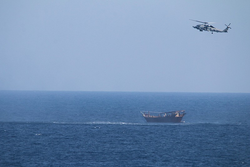 A U.S. Navy Seahawk helicopter flies over a stateless dhow later found to be carrying a hidden arms shipment in the Arabian Sea on Thursday, May 6, 2021. The U.S. Navy announced Sunday it seized the arms shipment hidden aboard the vessel in the Arabian Sea, the latest-such interdiction by sailors amid the long-running war in Yemen. (U.S. Navy via AP)