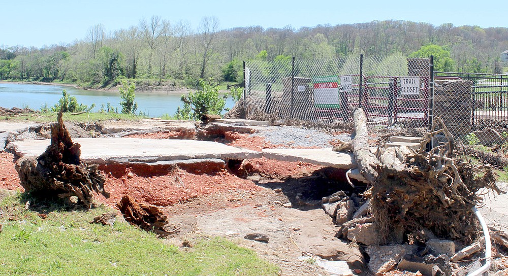 Keith Bryant/The Weekly Vista
A great deal of concrete is undercut and washed out while massive objects, including a tree snag, remain after being onto the former entryway for the Lake Bella Vista Dam during a late April rainstorm.
