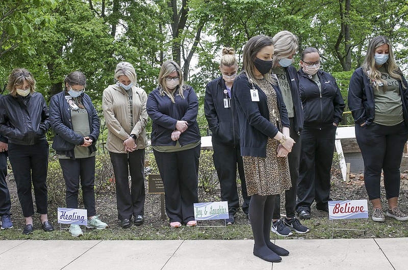 Attendees bow their heads for a moment of silence, Monday at the Bergant Terrace at Mercy Hospital Northwest Arkansas in Rogers. Mercy held a day of remembrance titled "Brighter Days Ahead Because of You" to recognize health care workers for their compassionate service and sacrifices during the covid-19 pandemic. Check out nwaonline.com/2105111Daily/ for today's photo gallery. 
(NWA Democrat-Gazette/Charlie Kaijo)