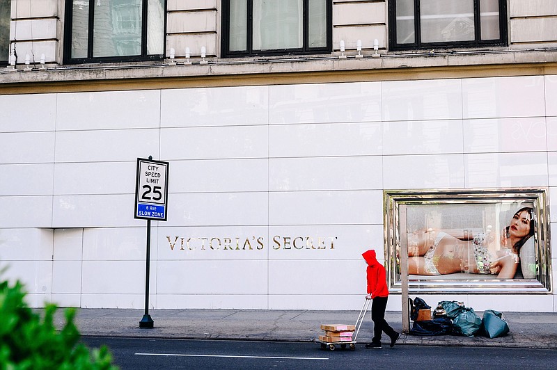 A worker pushes a cart in front of a Victoria's Secret store in New York, on May 5, 2020. MUST CREDIT: Bloomberg photo by Nina Westervelt.