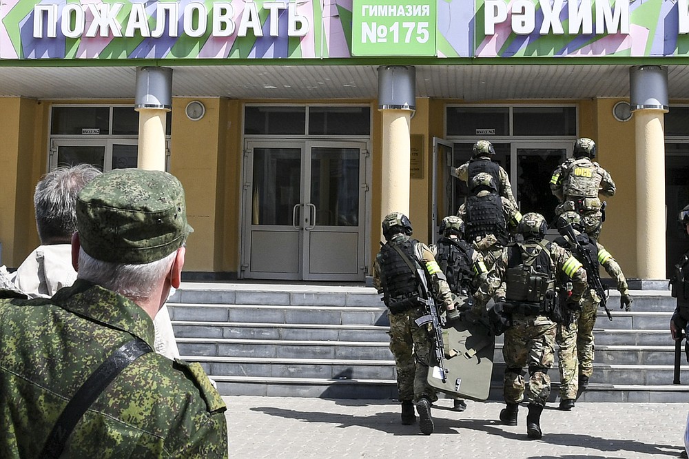 In this photo released by Tatarstan Presidential Press Service, Russian police special unit near the scene at a school after a shooting in Kazan, Russia, Tuesday, May 11, 2021. Russian media report that several people have been killed and wounded in a school shooting in the city of Kazan. Russia's state RIA Novosti news agency reported the shooting took place Tuesday morning, citing emergency services. (Tatarstan Presidential Press Service via AP)