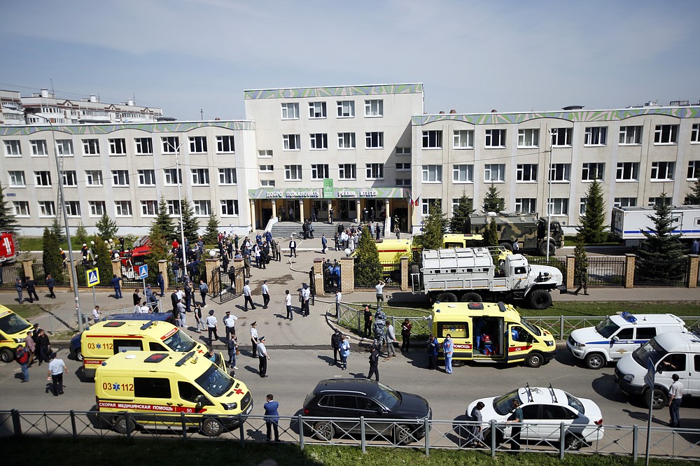 Ambulances and police cars and a truck are parked at a school after a shooting in Kazan, Russia, Tuesday, May 11, 2021. Russian media report that several people have been killed and wounded in a school shooting in the city of Kazan. Russia's state RIA Novosti news agency reported the shooting took place Tuesday morning, citing emergency services. (AP Photo/Roman Kruchinin)