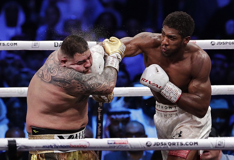 Defending champion Andy Ruiz Jr., left, takes a right cross to the face during his Dec. 8, 2019, fight against Britain's Anthony Joshua in their World Heavyweight Championship contest at the Diriyah Arena, Riyadh, Saudi Arabia. - Photo by Hassan Ammar of The Associated Press