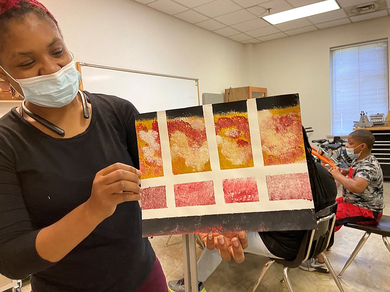 Shakeelah Rahmaan, the Arts and Science Center for Southeast Arkansas’ public programs coordinator, shows what a completed art piece might look like. She prepared art bags for seniors who participate in the art program at the University of Arkansas for Medical Sciences (UAMS) South Central Center for Aging at White Hall. (Special to The Commercial/Deborah Horn)