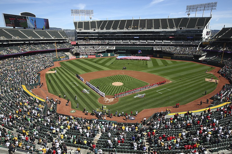 FILE - The Los Angeles Angels and Oakland Athletics stand for the national anthem at the Oakland Coliseum prior to an opening day baseball game in Oakland, Calif., in this Thursday, March 29, 2018, file photo.Major League Baseball instructed the Athletics to explore relocation options as the team tries to secure a new ballpark it hopes will keep the club in Oakland in the long term. MLB released a statement Tuesday, May 11, 2021, expressing its longtime concern that the current Coliseum site is “not a viable option for the future vision of baseball.” (AP Photo/Ben Margot, File)