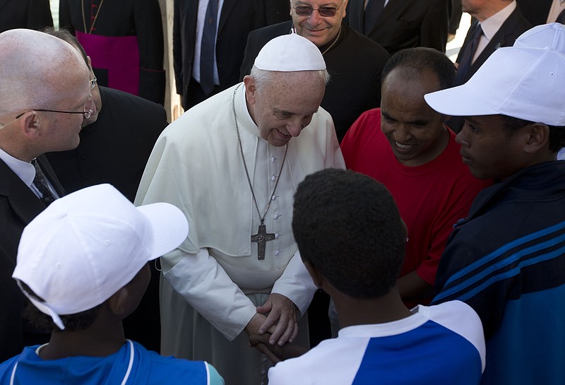 Pope Francis speaks to migrants, some wearing white caps, during his visit to the island of Lampedusa, southern Italy in 2013. Pope Francis on Tuesday created a lay ministry that encourages secular men and women in teaching the Catholic faith, officially recognizing a practice that has been in use for centuries.
(AP/Alessandra Tarantino, pool)