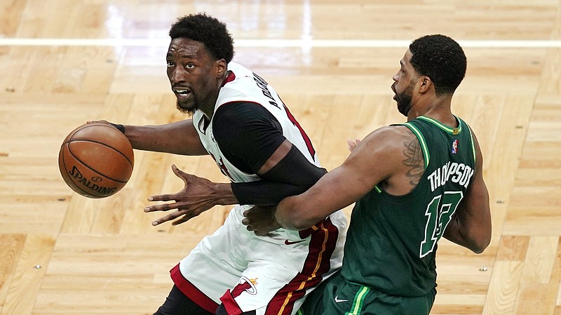 Miami Heat center Bam Adebayo, left, drives to the basket past Boston Celtics center Tristan Thompson during the second half of Tuesday's game in Boston. - Photo by Charles Krupa of The Associated Press