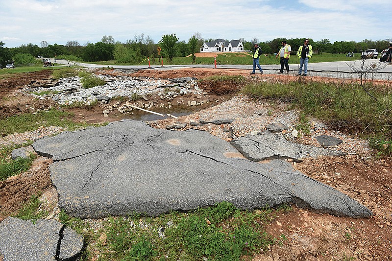 In this Wednesday May 12 2021 file photo Benton County officials look at flood damage to Col. Meyers Road 100 yards north of Wager Road in Cave Springs. Tim Gehring with the Arkansas Department of Emergency Management also inspected the flood damage, one of hundreds of damage sites he will assess in the next two weeks, to seek funds from the Federal Emergency Management Agency. 
(NWA Democrat Gazette/Flip Putthoff)