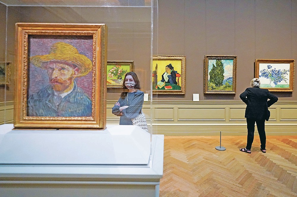 Visitors to the Metropolitan Museum of Art inspect Van Gogh paintings, Thursday, April 29, 2021, in New York. In recent weeks, tourism indicators for New York City like hotel occupancy and museum attendance that had fallen off a pandemic cliff have ticked up slightly. It's a welcome sight for a city where the industry has been decimated by the impact of the coronavirus. (AP Photo/Mary Altaffer)