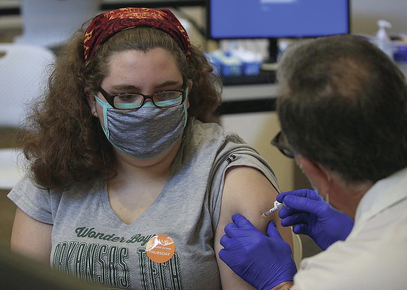 Emily Parker, left, 15, of Russellville gets her first dose of the Pfizer covid vaccine Thursday May 13, 2021 in Little Rock from Physicians Assistant Rafael Rodriguez at the University of Arkansas for Medical Sciences vaccination clinic at the Centre at University Park. (Arkansas Democrat-Gazette/Staton Breidenthal)