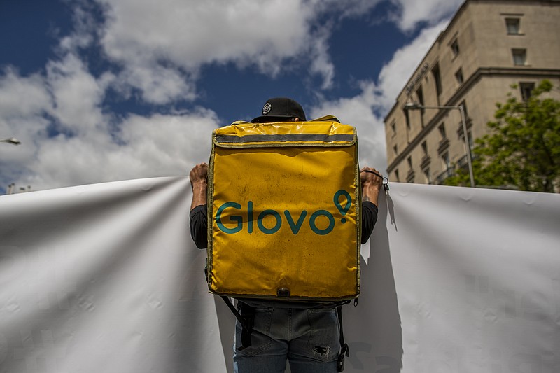 A delivery worker protests in front of the Spanish Parliament in Madrid, Spain, Tuesday, May 11, 2021. Spain has approved a pioneering law that gives delivery platforms a mid-August deadline to hire the workers currently freelancing for them and that requires transparency of artificial intelligence to manage workforces. (AP Photo/Manu Fernandez)